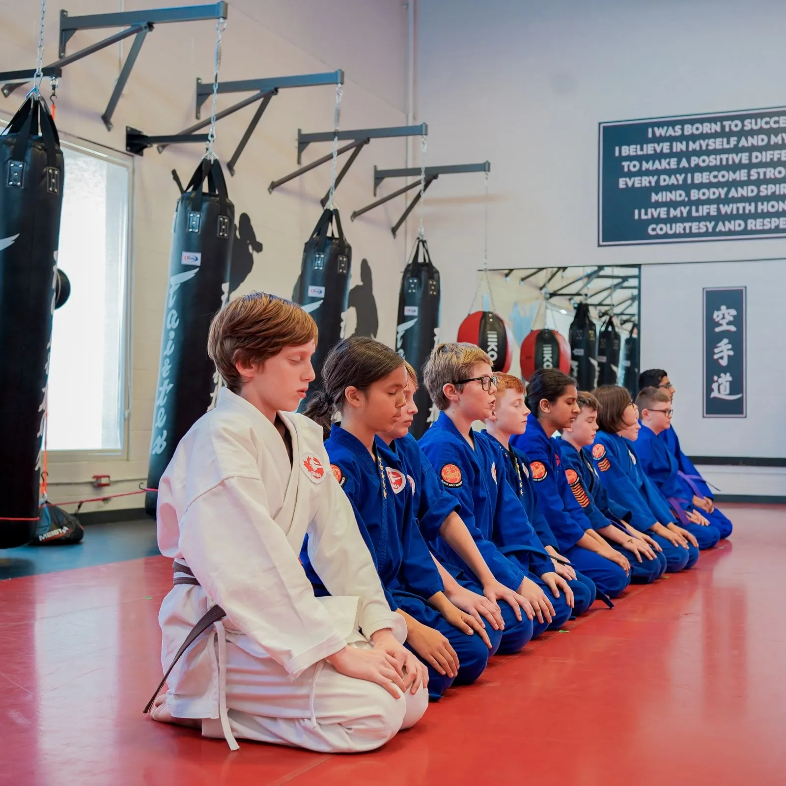 Students kneeling in a line at the start of class