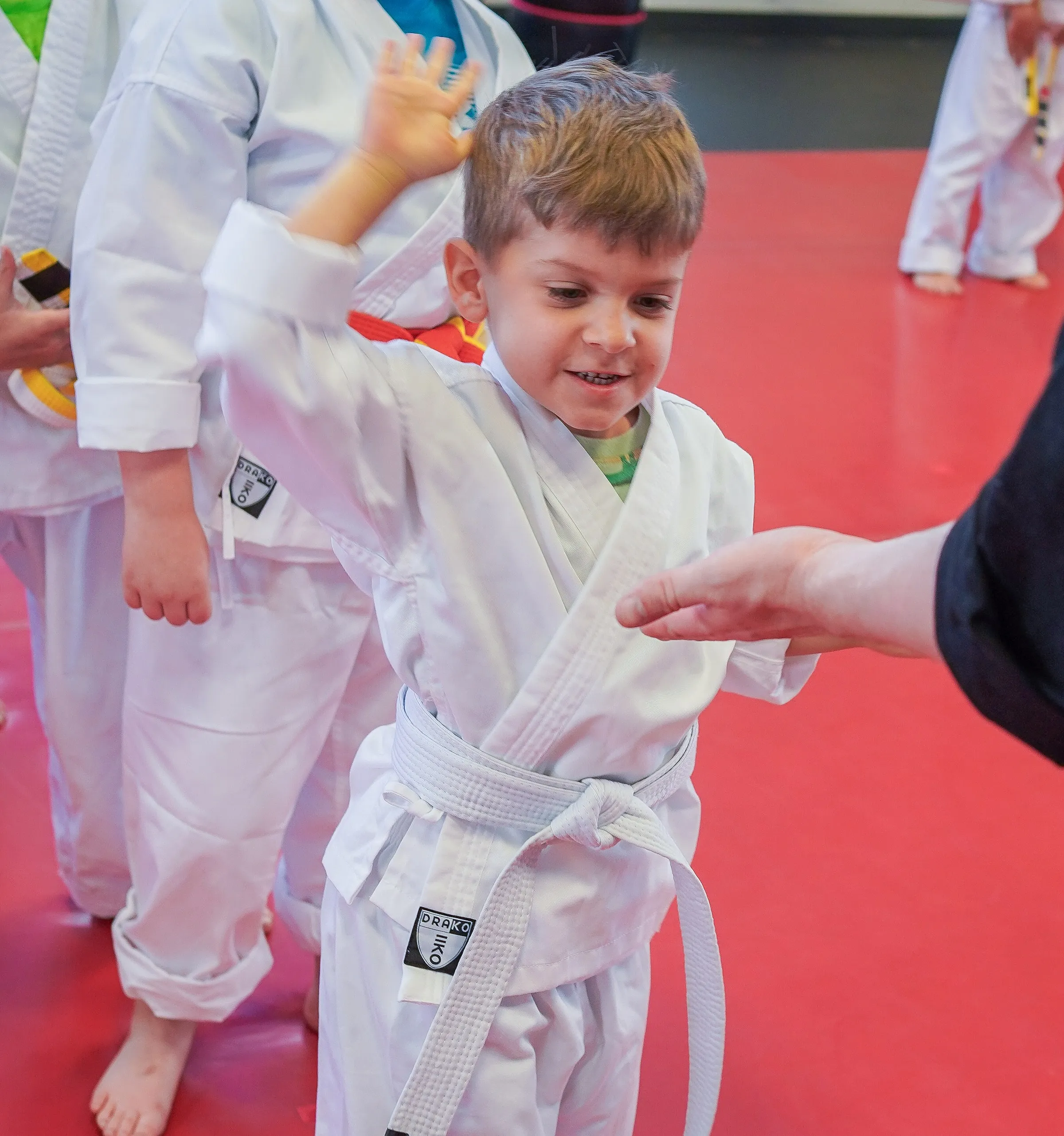 A smiling young student practising his first karate moves