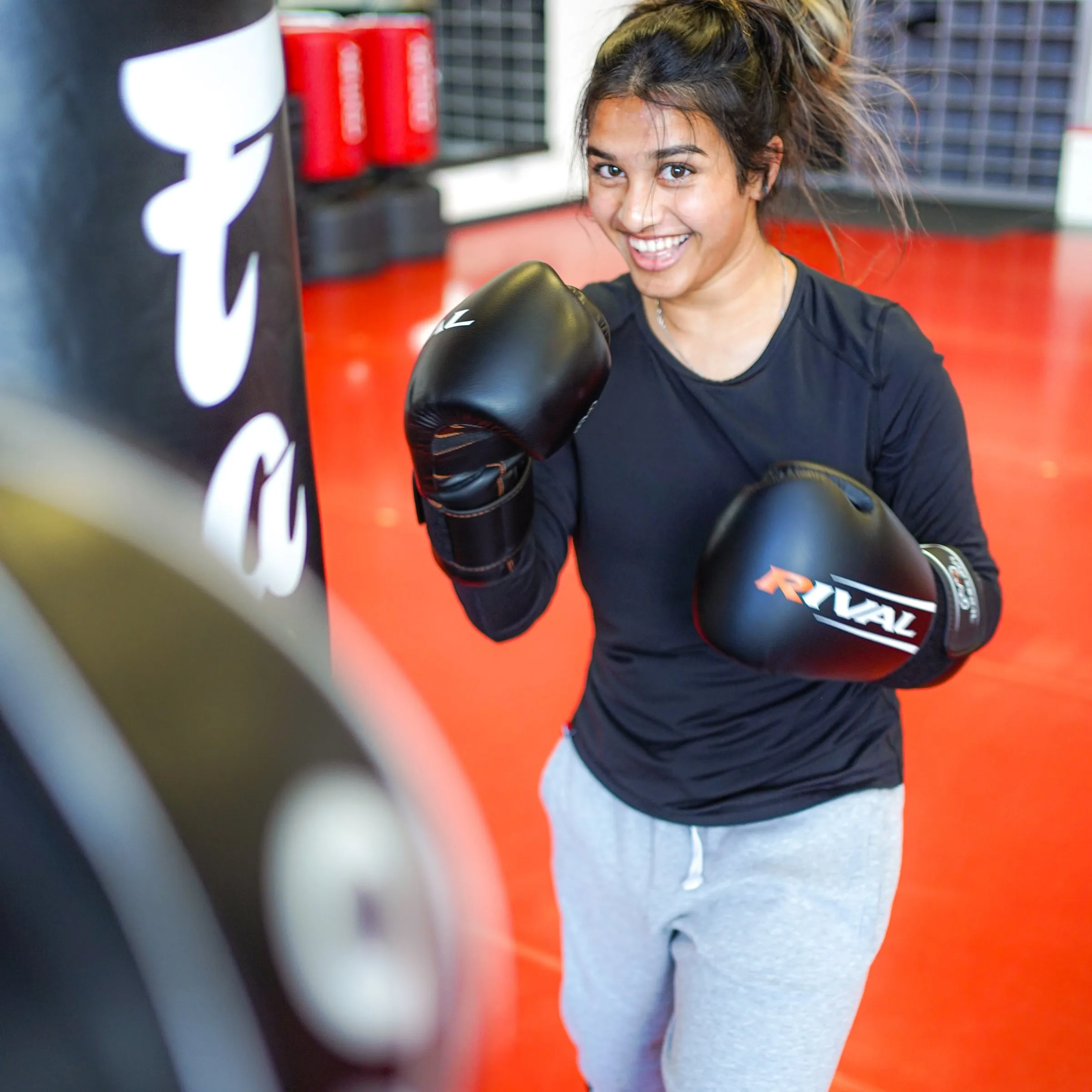A smiling student in boxing gloves between rounds